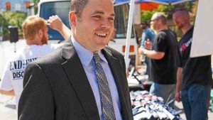 Dale Kerns at an outdoor event wearing suit and tie and smiling toward someone other than the photographer (color photo)