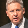 Gary Johnson wearing grey suit blue tie speaking at microphone at national Libertarian Party convention in 2016 (color photo)