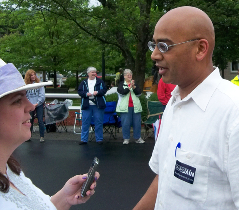 Libertarian candidate Kamal Jain speaking with a reporter at a parade